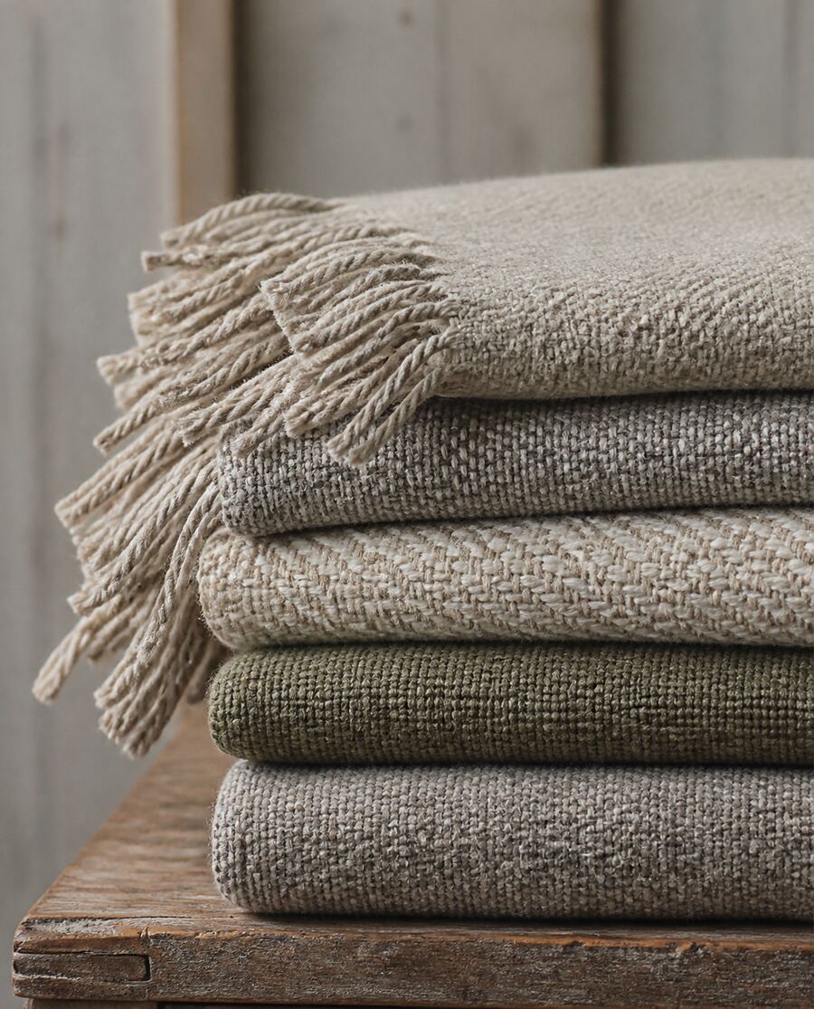 A folded stack of handwoven woollen blankets